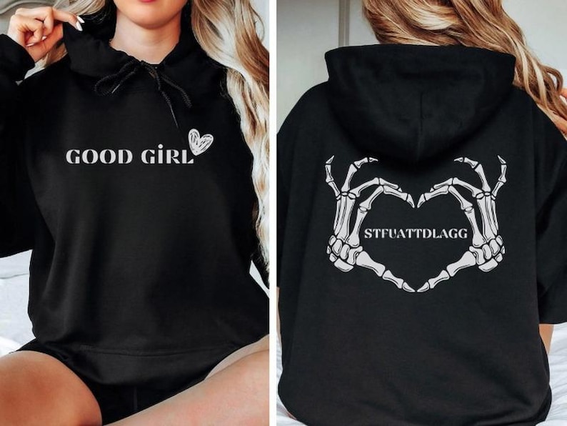 May include: Black hoodie with the words "GOOD GIRL" and a heart graphic on the front. The back of the hoodie features a heart made of skeleton hands with the text "STFUATTDLAGG".