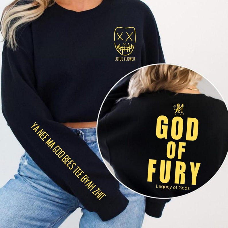 May include: Black sweatshirt with gold text and graphics. The front features a stylized face and the words "LOTUS FLOWER." The left sleeve has text. The back displays "GOD OF FURY" and "Legacy of Gods."