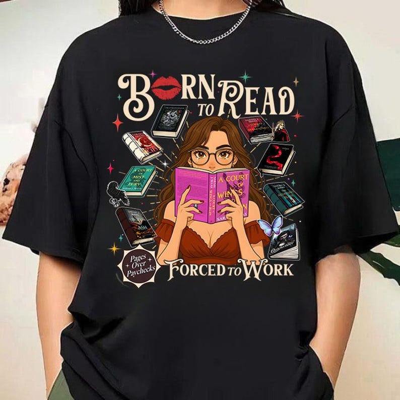 May include: Black t-shirt with the text "Born to Read, Forced to Work." The graphic features a woman reading a book, surrounded by other books and a butterfly. The phrase "Pages over Paychecks" is also included.