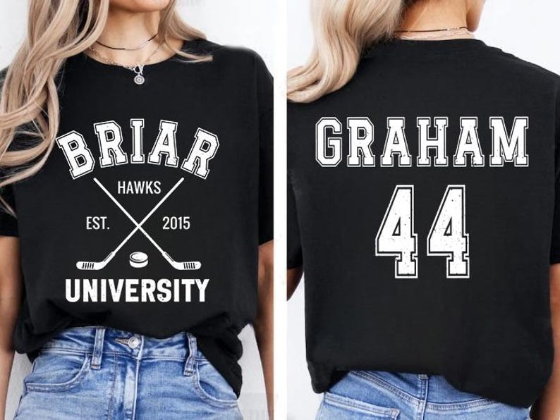 May include: Black t-shirt with white text and graphics. The front features "BRIAR HAWKS UNIVERSITY" with crossed hockey sticks and a puck. The back displays "GRAHAM 44". A collegiate-themed apparel item.