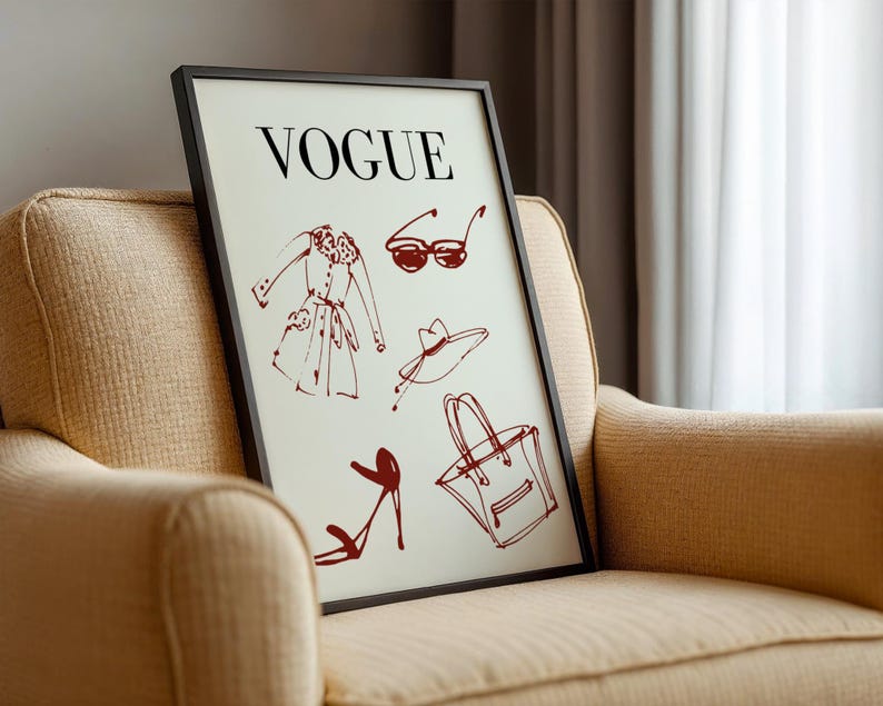 K&ouml;nnte beinhalten: Ein gerahmter Druck mit dem Wort "VOGUE" &uuml;ber roten Skizzen von Modeaccessoires. Die Skizzen umfassen einen Mantel, eine Sonnenbrille, einen Hut, eine Handtasche und High-Heels. Der Druck wird auf einem beigen Sessel pr&auml;sentiert.