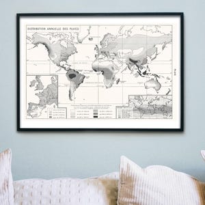 May include: Framed vintage map print depicting annual rainfall distribution across the globe. The black and white map features detailed geographical information, including continents and oceans. The print is displayed in a black frame, suitable for home or office decor.