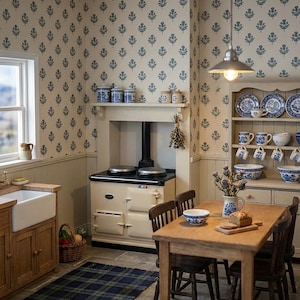 May include: A miniature kitchen scene featuring a cream-colored range stove, a wooden dining table with chairs, a hutch filled with blue and white patterned dishware, a farmhouse sink, and wallpaper with a repeating blue floral motif on a cream background.