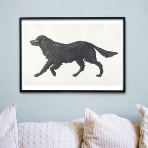 May include: Black and white framed print of a dog in a running pose. The dog is a dark color with detailed fur, set against a white background. The artwork is displayed on a light blue wall above a white couch.