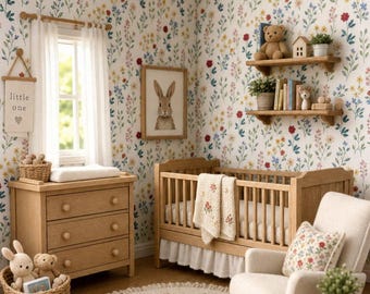 May include: A miniature nursery room featuring floral wallpaper, a wooden crib with a white blanket, a wooden dresser, a rocking chair with a floral pillow, two wall shelves with toys, a round rug, and a basket containing plush animals.