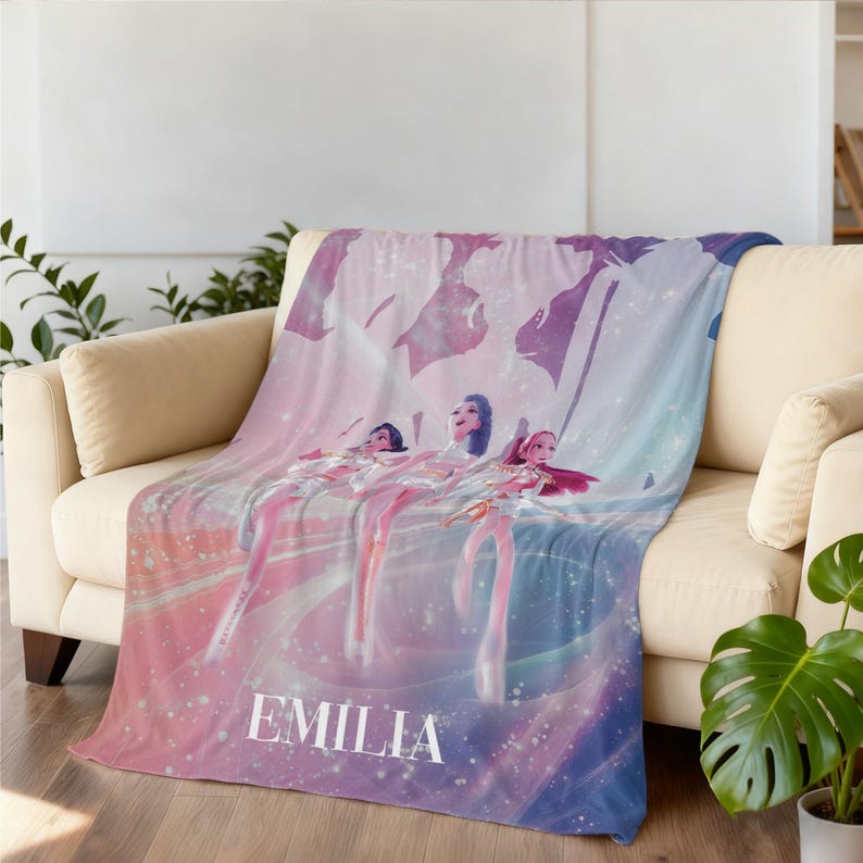 May include: A soft, plush blanket featuring a digital art design of three figures in a dreamy, pastel-colored scene. The blanket has a gradient of pink, purple, and blue hues, with the name "EMILIA" printed in white.