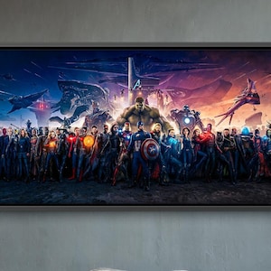Op de afbeelding: Een ingelijst kunstwerk met een grote groep kostuumfiguren tegen een dramatische lucht. De kamer heeft twee grijze fauteuils, een kleine houten tafel, een gouden hanglamp en een grote plant in pot, alles tegen een grijze muur.