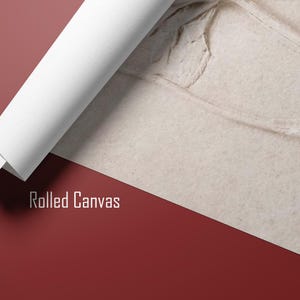 Puede incluir: Impresi&oacute;n en lienzo enrollado con una superficie beige texturizada, parcialmente desenrollada para revelar un dise&ntilde;o floral detallado. La parte enrollada es blanca, contrastando con el fondo rojo-marr&oacute;n. El texto "Rolled Canvas" est&aacute; impreso en blanco.