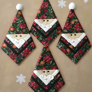 May include: Four Christmas tree-shaped decorations with Santa Claus faces. The decorations feature a festive floral pattern with red poinsettias, green leaves, and orange fruits. Each has a white beard, bow tie, and a black stripe.