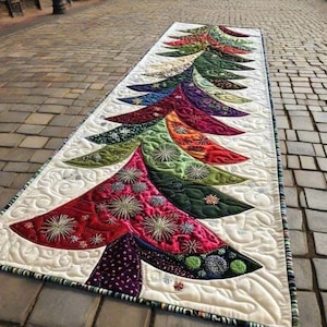 Könnte beinhalten: Ein farbenfroher Tischläufer mit Weihnachtsbaum-Motiv. Das Baumdesign weist verschiedene Rot-, Grün-, Blau- und Lilatöne mit gestickten Sternenmustern auf. Der Läufer ist etwa 152 cm lang und aus gestepptem Stoff gefertigt.