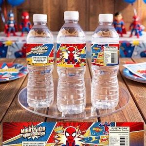 Pu&ograve; includere: Tre bottiglie d'acqua in plastica trasparente con etichette personalizzate raffiguranti un supereroe rosso e blu, grafiche in stile fumetto, il testo Mighty H20 Hero Hydration e una tabella dei valori nutrizionali di compleanno.