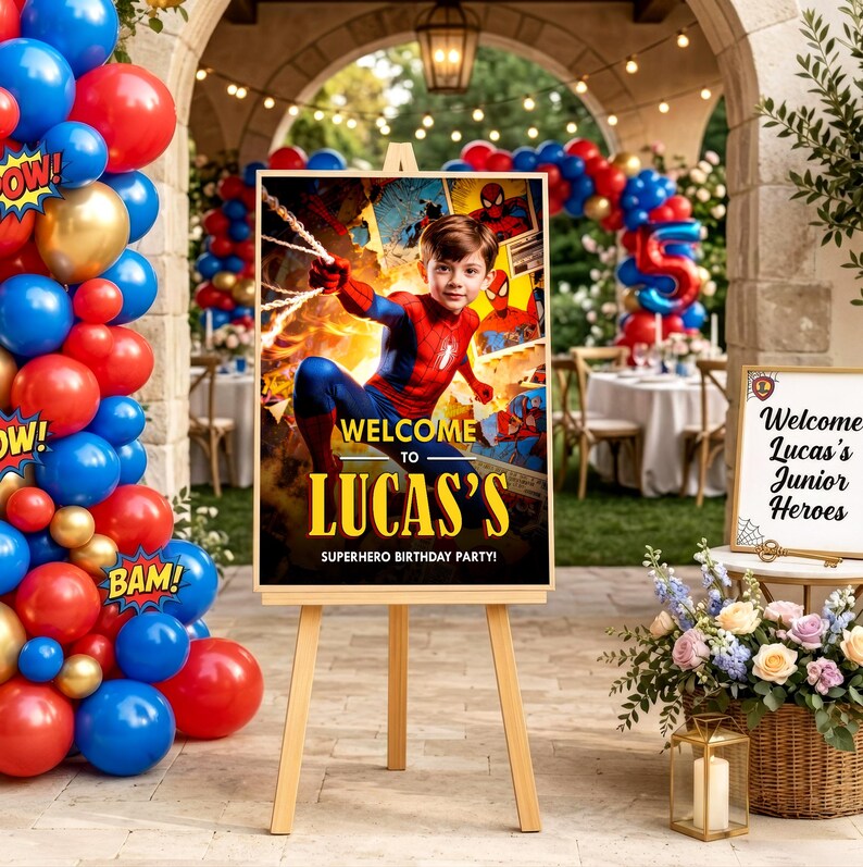 Pu&ograve; includere: Un cartello rettangolare per festa di compleanno su un cavalletto in legno con un bambino vestito da supereroe e il testo Welcome to Lucas's Superhero Birthday Party. Il cartello &egrave; circondato da palloncini rossi, blu e dorati.