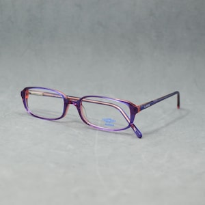 May include: Purple and red eyeglasses with a rectangular frame. The glasses have a thin metal frame with a purple finish and red accents on the temples. The lenses are clear, and the overall design is modern and stylish.