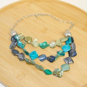 Turquoise and blue abalone shell statement necklace features chunky, freeform beads in iridescent shades