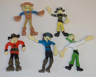 May include: A set of five flexible plastic character figurines. One wears a brown hat and boots, one a black pirate hat, one a red tunic with a cross, one a blue shirt with a cap, and one a white shirt with a green bandana and green pants.