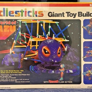 May include: Vintage Fiddlesticks Giant Toy Builder Set box featuring the World of Mazu. The box shows a purple monster with orange eyes, and colorful building sticks. Includes images of a Jet Cruiser, Giant Copter, and Giant Phaser Gun. The box is 42 inches long.