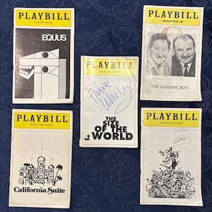 May include: A collection of vintage Playbills featuring various theater productions. The Playbills have yellow headers with black text, and include titles like "Equus," "The Sunshine Boys," and "California Suite." One Playbill is signed.