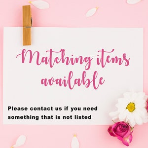 Pu&ograve; includere: Un cartoncino rettangolare bianco con il testo rosa Matching items available e il testo nero Please contact us if you need something that is not listed. Il cartoncino &egrave; fissato da una molletta di legno e decorato con fiori bianchi e rosa.