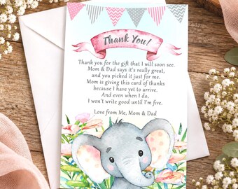 May include: A rectangular thank you card featuring a watercolor illustration of a baby elephant surrounded by flowers. At the top, a pink banner reads Thank You! with a bunting above. The text reads: Thank you for the gift that I will soon see.