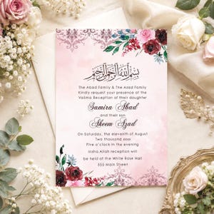 K&ouml;nnte beinhalten: Eine rechteckige Hochzeitseinladungskarte mit zartrosa Aquarellhintergrund, verziert mit dunkelroten und rosafarbenen Blumenillustrationen, ornamentalen Damastmustern und schwarzem Text, der den Valima-Empfang von Samira Abad und Akeem Azad ank&uuml;ndigt.