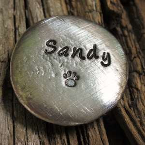 May include: Silver metal disc with the name "Sandy" engraved on it. A small paw print is also engraved on the disc.