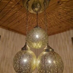 Moroccan lamp casting intricate lace shadows on the ceiling.