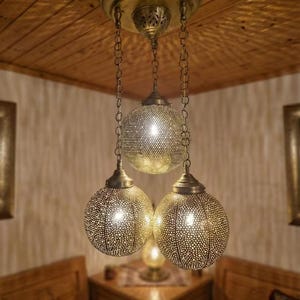 Detailed view of the brass ceiling canopy and chain links.