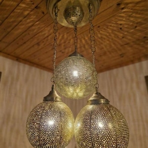 Gold bohemian pendant light cluster with intricate perforated patterns.