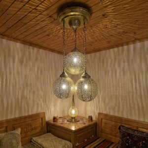 Close up of handmade perforated holes in brass lamp shade.