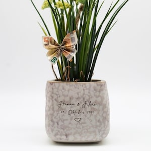 Peut inclure: Ensemble de trois mugs en céramique avec une finition mate et mouchetée. Les tasses sont de couleur crème, gris clair et gris foncé. Design simple et minimaliste.