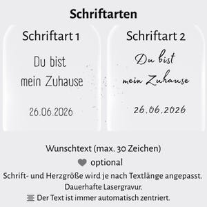 May include: Image showcasing two font styles with the text "Du bist mein Zuhause" and the date "26.06.2026". The image also includes the text "Wunschtext (max. 30 Zeichen) optional" and other details about the product.