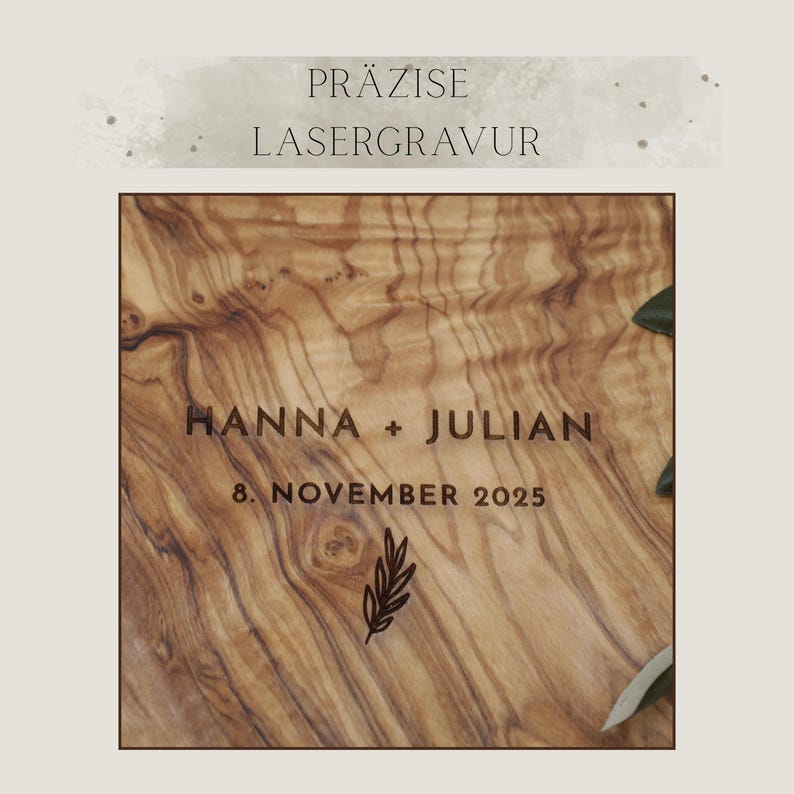 May include: A light brown olive wood surface featuring a dark laser-engraved design with the text HANNA + JULIAN, the date 8. NOVEMBER 2025, and a small leaf illustration. Above the wood, the text PR&Auml;ZISE LASERGRAVUR is displayed in dark font.