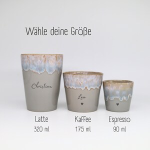 May include: Three ceramic cups with a grey base and a blue and white drip glaze rim. The cups are labeled Latte 320 ml, Kaffee 175 ml, and Espresso 90 ml. The text W&auml;hle deine Gr&ouml;&szlig;e is at the top. The cups feature the names Christian and Lea.