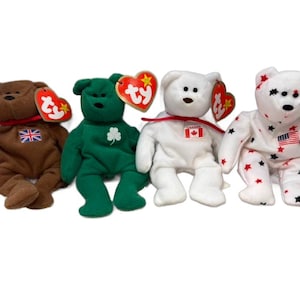 May include: Four plush teddy bears with patriotic and national flag designs. The bears are brown, green, white, and white with star patterns. Each bear has a tag attached. The flags include the UK, Ireland, Canada, and the USA.