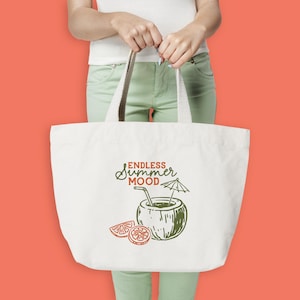 May include: A white tote bag with a cream-colored handle is held by a person. The bag features a green and orange illustration of a coconut drink with the words "Endless Summer Mood". The background is a solid coral color.
