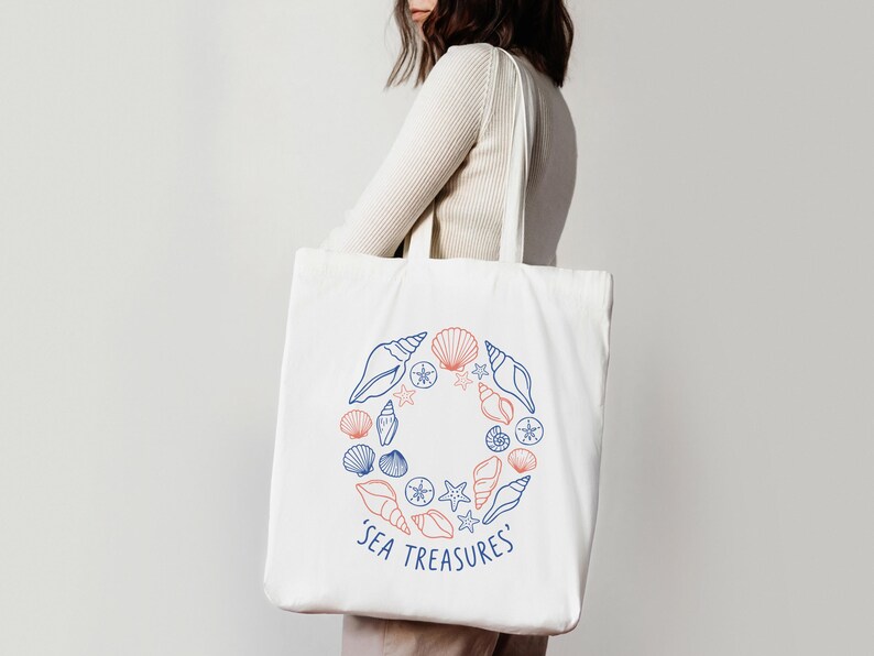 May include: White tote bag featuring a circular design of seashells and starfish in blue and coral. The words 'SEA TREASURES' are printed in blue below the design. The bag has a simple, clean design.