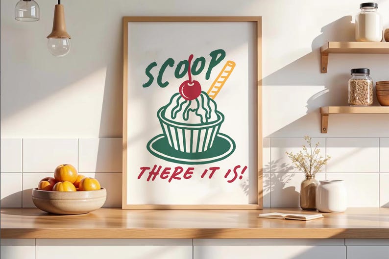 Pu&ograve; includere: Una stampa artistica da parete incorniciata con un'illustrazione grafica di una coppa gelato in una ciotola con una ciliegia sopra e un wafer. Il testo SCOOP THERE IT IS! &egrave; stampato in lettere verde scuro e rosse sopra e sotto il dessert.