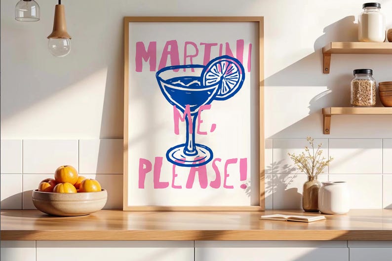 Pu&ograve; includere: Una stampa artistica da parete incorniciata con un'illustrazione a linee blu di un bicchiere da martini con una fetta di agrume. Il testo "MARTINI ME, PLEASE!" &egrave; stampato in un carattere rosa audace e scritto a mano su sfondo bianco.