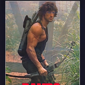 May include: Movie poster for "Rambo: First Blood Part II" featuring Sylvester Stallone. The title "STALLONE" is in red at the top, with the tagline "No man, no law, no war can stop him." The title "RAMBO" is in red at the bottom.