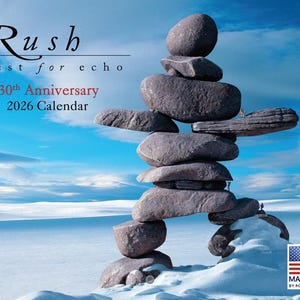 May include: A 2026 calendar featuring a balanced stone sculpture against a backdrop of a snowy landscape and blue sky. The calendar is labeled "Rush test for echo 30th Anniversary." Made in the USA.