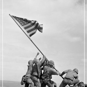 May include: Black and white photograph of U.S. Marines raising the American flag on Iwo Jima. The image shows six soldiers struggling to raise the flag on a pole. The text "IWO JIMA February 23, 1945" is at the bottom.
