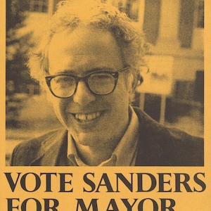 May include: A vintage poster with a sepia tone features a smiling man wearing glasses. The text reads "IT'S TIME FOR A CHANGE, A REAL CHANGE." Below, it says "VOTE SANDERS FOR MAYOR, INDEPENDENT COALITION, MARCH 3, 1981."