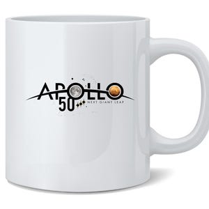 May include: White ceramic mug with a curved handle. The mug features the text "APOLLO 50" in black, with a stylized graphic of the moon and Mars. The words "NEXT GIANT LEAP" are below the graphic.