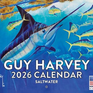 May include: A 2026 Guy Harvey saltwater calendar featuring a vibrant underwater scene. A large marlin swims with other fish in a blue ocean. The calendar includes the text "Guy Harvey 2026 Calendar Saltwater" and the American flag.