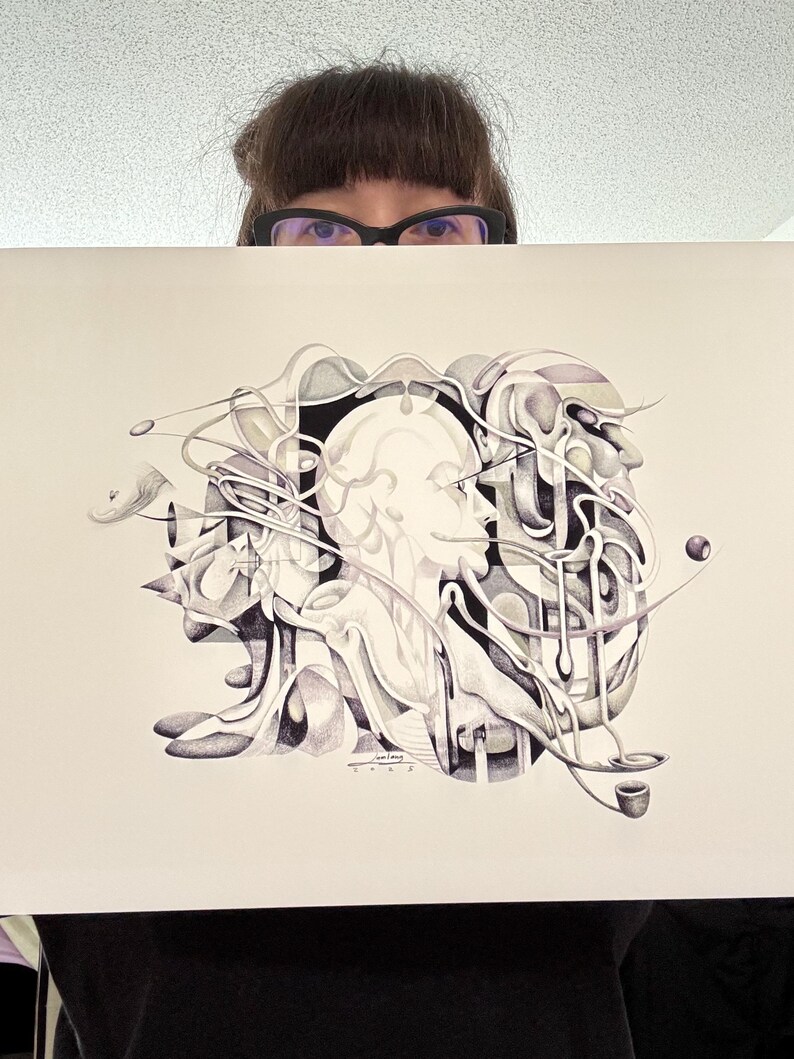 May include: Black and white abstract art print featuring a central human profile, surrounded by flowing, organic shapes. The artwork includes a pipe and a sphere, with intricate details and shading. The print is held by a person.