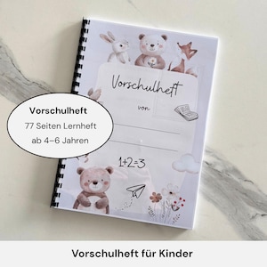 Könnte beinhalten: Ein spiralgebundenes Vorschulheft mit weißem Einband, der Aquarellillustrationen eines Kaninchens, eines Bären und eines Fuchses zeigt. Der Einband trägt den Titel "Vorschulheft" und den Hinweis auf das Alter 4-6 Jahre, mit 77 Seiten.