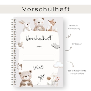 Könnte beinhalten: Ein spiralgebundenes Notizbuch mit dem Titel "Vorschulheft". Auf dem Cover sind Illustrationen eines Hasen, eines Bären und eines Fuchses zu sehen. Weitere Illustrationen sind ein Vogel, ein Schmetterling und Blumen. Das Notizbuch hat 87 Seiten und den Text "1+2=3".