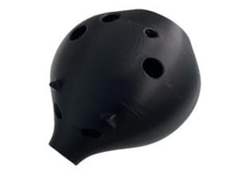 May include: A black ocarina, a wind instrument, is shown against a white background. The ocarina has a rounded shape with several finger holes and a mouthpiece. It has a matte finish and a smooth texture.