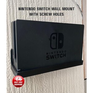 May include: Black Nintendo Switch wall mount with screw holes. The mount features the Nintendo Switch logo and text. A red and white "Fast Free Shipping" sticker is in the lower left corner.