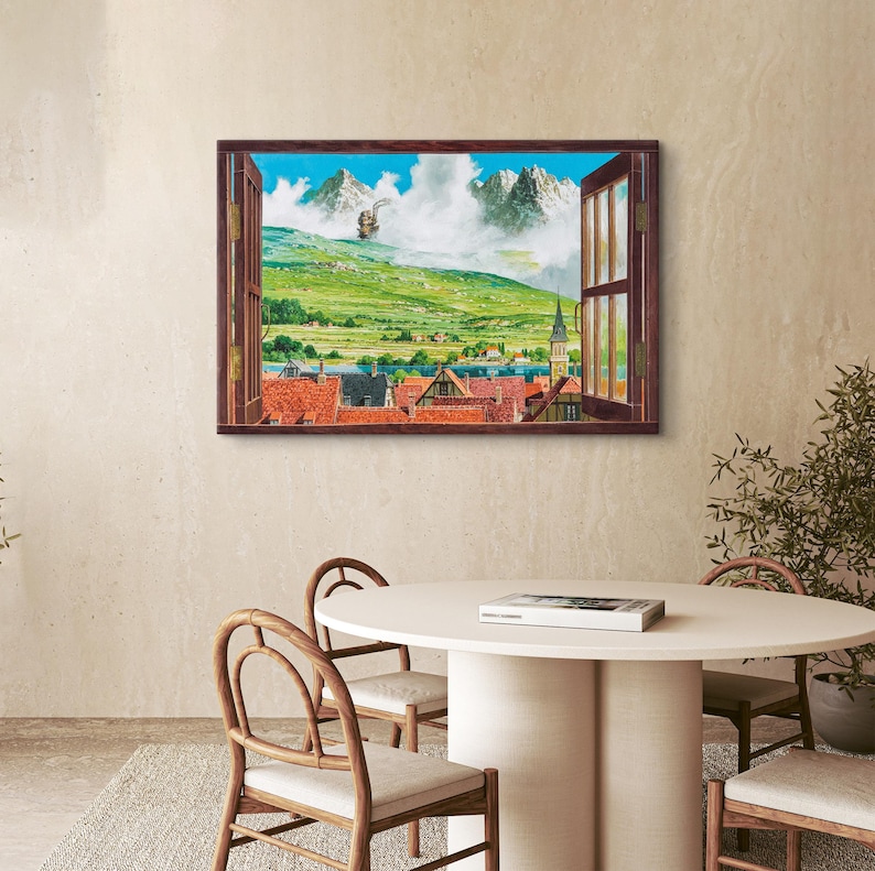 May include: A framed artwork depicting a scenic landscape viewed through an open window. The artwork showcases a vibrant green hillside, a village with red-tiled roofs, and distant snow-capped mountains under a blue sky. The window frame is a dark brown color.